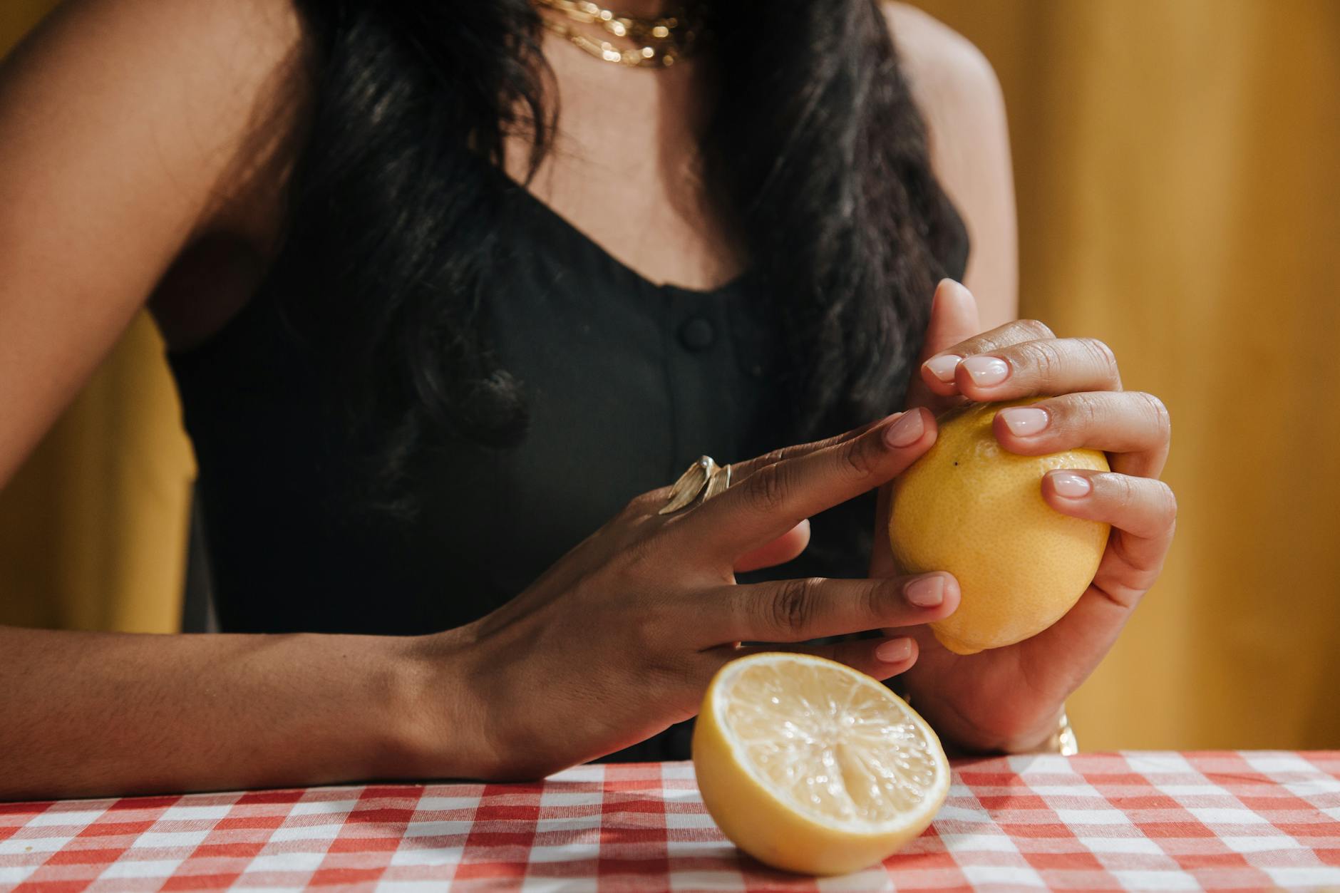 A teal lemon clitoral vibrator resting on smooth white silk fabric.