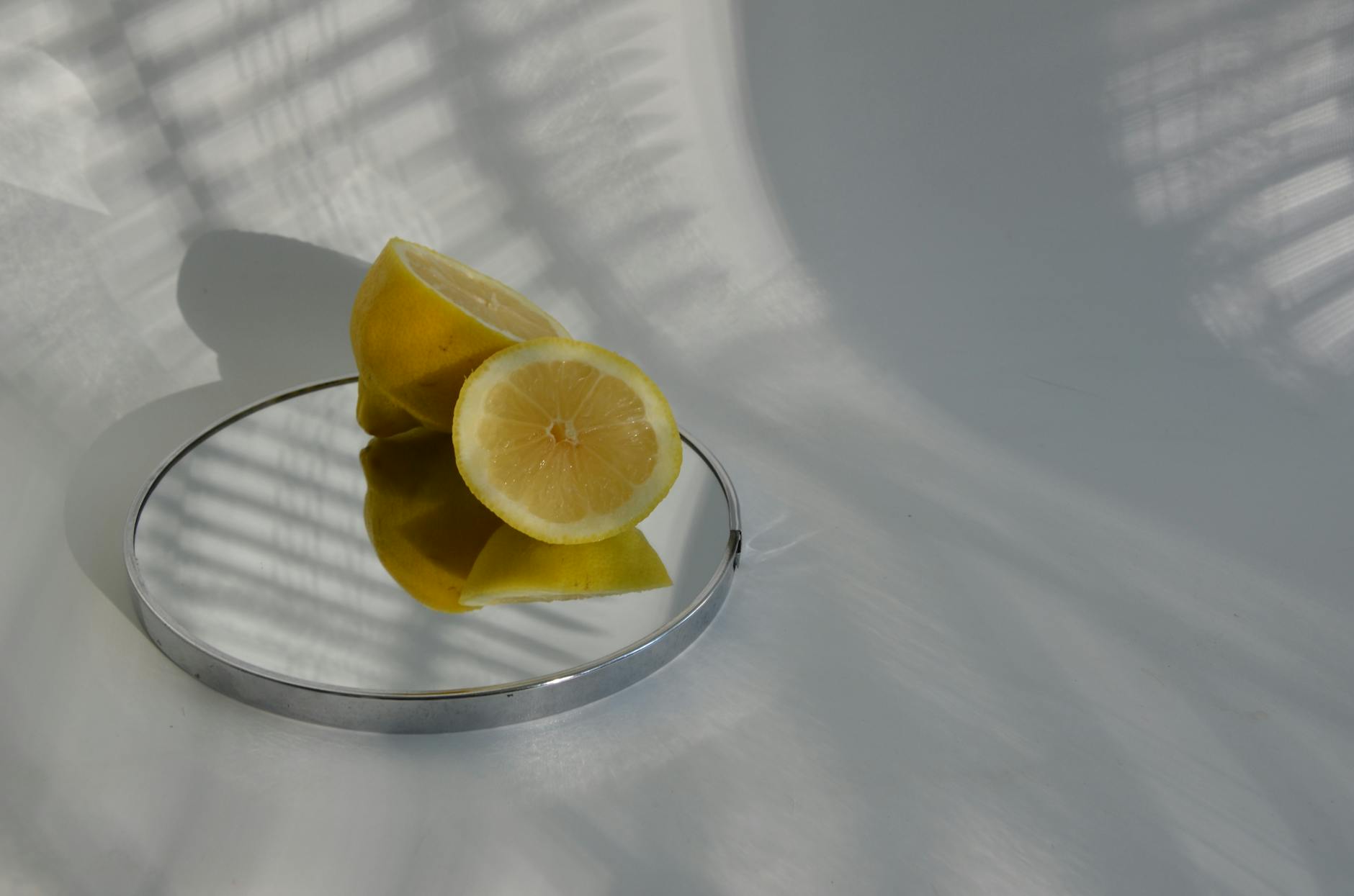 Close-up of fresh lemons on a clean surface with sharp shadows, symbolizing clarity and grounded sensation
